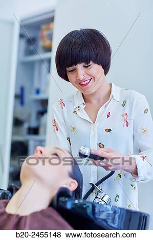 Stock Photo - Hairdresser washing hair of a woman. Hairdressers and Beauty Clinic. Hair salon.. Fotosearch