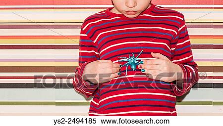 Little girl holding a plastic toy spider in her hands. Conceptual image of childhood curiosity, fantasy and adventure. View Large Photo Image Stock Photography - Little girl holding a plastic toy spider in her hands. Conceptual image of childhood curiosity, fantasy and adventure.. Fotosearch