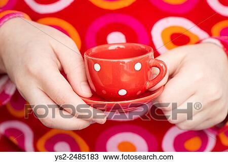 Little girl holding dotted tea cup playing teaparty. Close up of hands of child. The image shows an adorable moment of innocent childhood play. View Large Photo Image Stock Image - Little girl holding dotted tea cup playing teaparty. Close up of hands of child. The image shows an adorable moment of innocent childhood play.. Fotosearch
