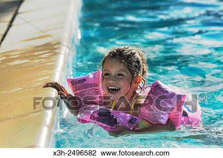 Stock Image - little girl in swimming pool, Ile-de-France, France, Europe.. Fotosearch