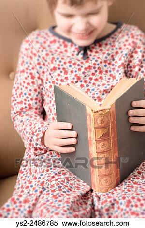 Little girl reading in an old book. Conceptual image of intelligence and learning to read at a young age. View Large Photo Image Stock Photography - Little girl reading in an old book. Conceptual image of intelligence and learning to read at a young age.. Fotosearch