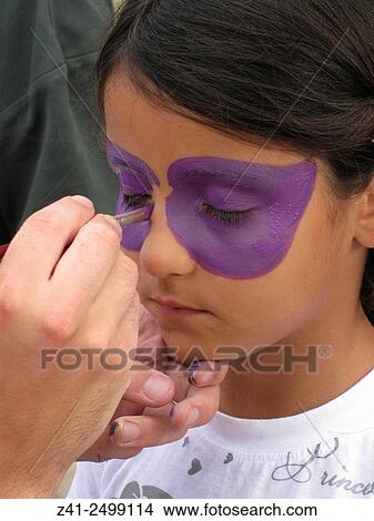 Little girls face is painted with purple paint. View Large Photo Image Picture - Little girls face is painted with purple paint.. Fotosearch