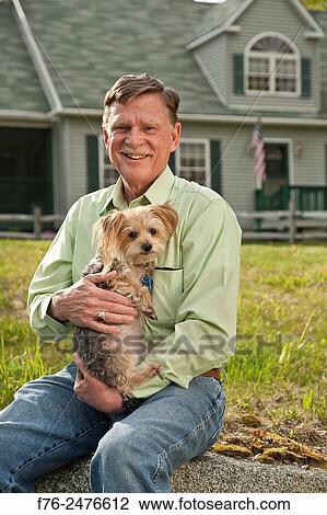 Man in blue jeans (MR# G120513, sitting in front of his home, holding his small yorkshire terrier. View Large Photo Image Stock Image - Man in blue jeans (MR# G120513, sitting in front of his home, holding his small yorkshire terrier.. Fotosearch