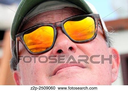 Stock Image - Man in yellow sunglasses on boat in Azores islands.. Fotosearch