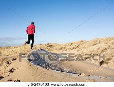 Man jogging on frost coverd dunes on Seaton Carew beach, north east England, United Kingdom. View Large Photo Image Stock Image - Man jogging on frost coverd dunes on Seaton Carew beach, north east England, United Kingdom.. Fotosearch