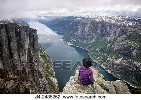 Stock Image - Norway, Rogaland, Lysefjord, Kjerag (Kiragg), hiker watching the fjord 1000m below, Model Released.. Fotosearch