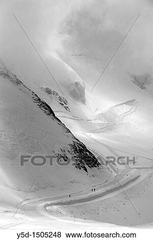 Stock Photo - people on the snowy road, Swiss Alps, high mountains, close to Saas Fee, Switzerland. Fotosearch