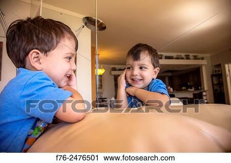 portrait of 3 year old boy, mr# 6302, amusing himself by playing with his image in a mirror. View Large Photo Image Stock Image - portrait of 3 year old boy, mr# 6302, amusing himself by playing with his image in a mirror.. Fotosearch