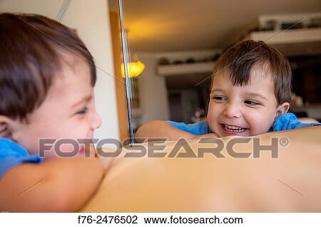 portrait of 3 year old boy, mr# 6302, amusing himself by playing with his image in a mirror. View Large Photo Image Stock Image - portrait of 3 year old boy, mr# 6302, amusing himself by playing with his image in a mirror.. Fotosearch