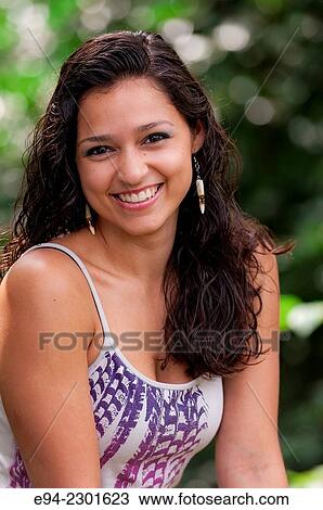 Stock Image - Portrait of a 19 year old brunette woman smiling at the camera.. Fotosearch