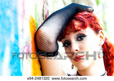 Portrait of a 23 year old red head woman standing in front of a graffiti covered rock wall. View Large Photo Image Stock Image - Portrait of a 23 year old red head woman standing in front of a graffiti covered rock wall.. Fotosearch