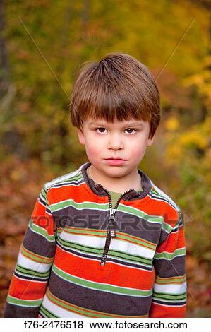 Portrait of a 3 year old boy with a forlorn look, standing outdoors in the fall. View Large Photo Image Stock Photo - Portrait of a 3 year old boy with a forlorn look, standing outdoors in the fall.. Fotosearch