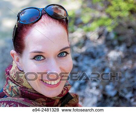Portrait of a 37 year old redheaded woman with sunglasses on her head looking at the camera, outdoors. View Large Photo Image Stock Photo - Portrait of a 37 year old redheaded woman with sunglasses on her head looking at the camera, outdoors.. Fotosearch