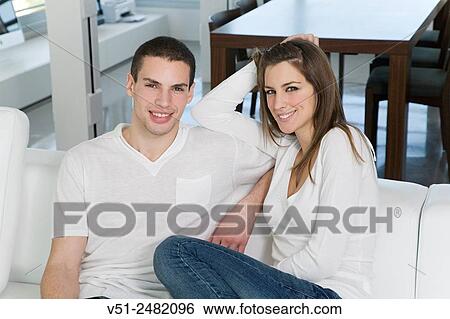 Portrait of a beautiful couple in sofa smiling at camera View Large Photo Image Stock Photograph - Portrait of a beautiful couple in sofa smiling at camera. Fotosearch