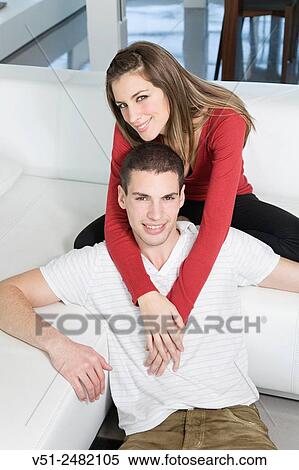 Portrait of a beautiful couple in sofa smiling at camera View Large Photo Image Stock Photography - Portrait of a beautiful couple in sofa smiling at camera. Fotosearch