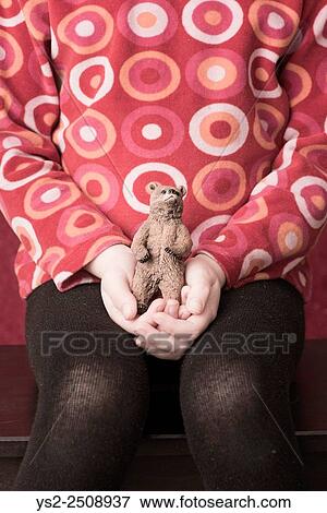 Stock Photo - Portrait of little girl holding plastic toy bear in her hands.. Fotosearch