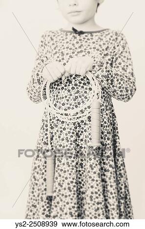 Portrait of little girl in dress with flowers. She is holding a jump rope in her hands. View Large Photo Image Stock Photo - Portrait of little girl in dress with flowers. She is holding a jump rope in her hands.. Fotosearch