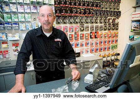 Rotterdam, Netherlands. The chief sales man of a store, talking to a customer, from behind his counter. View Large Photo Image Stock Photo - Rotterdam, Netherlands. The chief sales man of a store, talking to a customer, from behind his counter.. Fotosearch