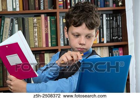 Stock Image - Russia. Belgorod region. Tavrovsky rural settlement. The village Solomino. Schoolboy doing homework.. Fotosearch