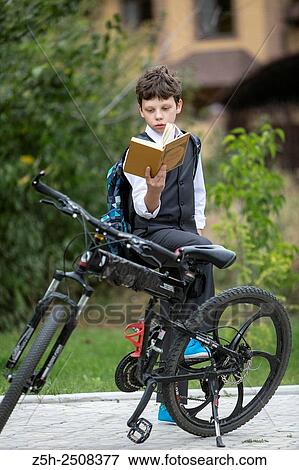 Stock Photo - Russia. Belgorod region. Tavrovsky rural settlement. The village Solomino. Boy on bike rides to school.. Fotosearch