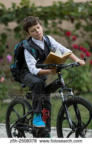 Stock Photo - Russia. Belgorod region. Tavrovsky rural settlement. The village Solomino. Boy on bike rides to school.. Fotosearch