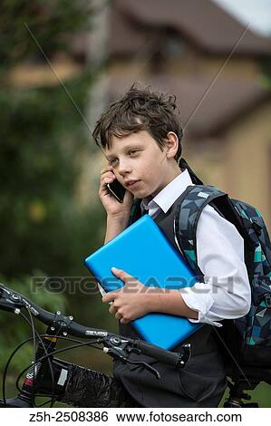 Stock Photograph - Russia. Belgorod region. Tavrovsky rural settlement. The village Solomino. Boy on bike rides to school.. Fotosearch