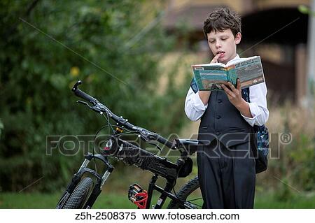 Stock Photography - Russia. Belgorod region. Tavrovsky rural settlement. The village Solomino. Boy on bike rides to school.. Fotosearch