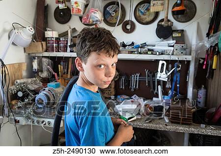 Stock Image - Russia. Belgorod region. The boy in the garage making repairs bicycles.. Fotosearch