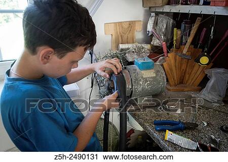 Stock Image - Russia. Belgorod region. The boy in the garage making repairs bicycles.. Fotosearch