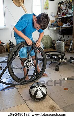 Stock Image - Russia. Belgorod region. The boy in the garage making repairs bicycles.. Fotosearch