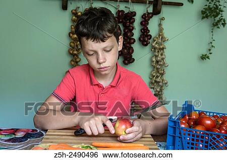 Russia. Boy cut raw vegetables on the kitchen table. View Large Photo Image Stock Photograph - Russia. Boy cut raw vegetables on the kitchen table.. Fotosearch