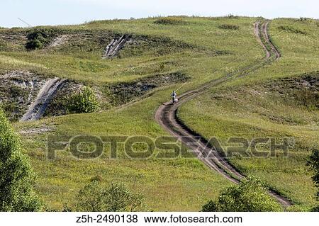 Stock Photo - Russian Federation. Belgorod region. The boy goes on a fishing trip on the country road.. Fotosearch