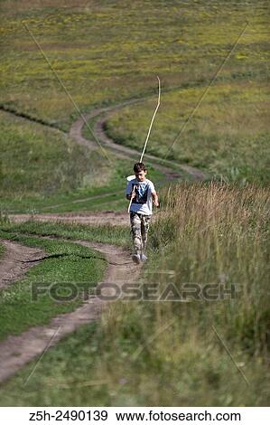 Russian Federation. Belgorod region. The boy goes on a fishing trip on the country road. View Large Photo Image Stock Photo - Russian Federation. Belgorod region. The boy goes on a fishing trip on the country road.. Fotosearch