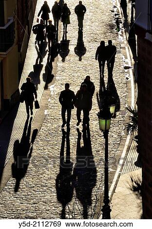 seen from above silhouettes of people walking paved street, strong shadows, old town of Cadiz, Andalusia, Spain View Large Photo Image Stock Photo - seen from above silhouettes of people walking paved street, strong shadows, old town of Cadiz, Andalusia, Spain. Fotosearch
