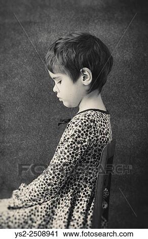Side view portrait of little girl in dress with flowers. She is sitting on a chair, lokking down with a pensive expression. View Large Photo Image Stock Image - Side view portrait of little girl in dress with flowers. She is sitting on a chair, lokking down with a pensive expression.. Fotosearch