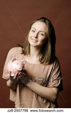 Stock Photo - Smiling your woman holding a piggy bank.. Fotosearch