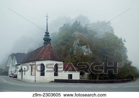 Stock Photography - St Wolfgang Chapel in Balsthal on a foggy day, canton of Solothurn, Switzerland.. Fotosearch