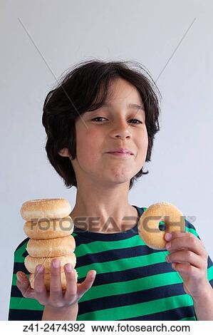 Teenage boy with a pil of donuts on his hand. View Large Photo Image Stock Image - Teenage boy with a pil of donuts on his hand.. Fotosearch