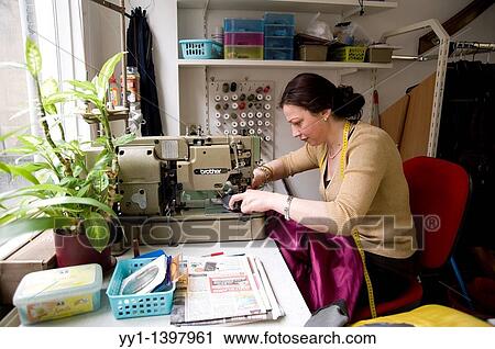 The hague, Netherlands. A young Polish immigrant working at a sewing workshop, repairing clothes. View Large Photo Image Stock Image - The hague, Netherlands. A young Polish immigrant working at a sewing workshop, repairing clothes.. Fotosearch