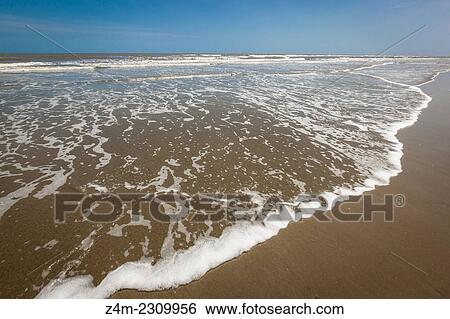 The ocean surf comes up onto a flat sandy beach on a sunny day. Coastal Georgia, USA View Large Photo Image Stock Photograph - The ocean surf comes up onto a flat sandy beach on a sunny day. Coastal Georgia, USA. Fotosearch