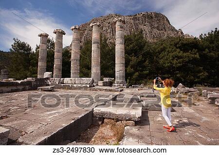 Tourist taking photos at the Temple of Athena, the ancient city of Priene, Aydin Province, Turkey, Europe. View Large Photo Image Stock Image - Tourist taking photos at the Temple of Athena, the ancient city of Priene, Aydin Province, Turkey, Europe.. Fotosearch