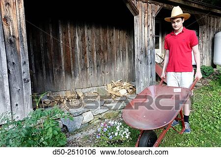 WEST CORNWALL CT. USA Boy with wheelbarrow doing yard work. View Large Photo Image Stock Photograph - WEST CORNWALL CT. USA Boy with wheelbarrow doing yard work.. Fotosearch