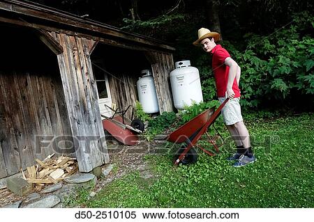 WEST CORNWALL CT. USA Boy with wheelbarrow doing yard work. View Large Photo Image Stock Photography - WEST CORNWALL CT. USA Boy with wheelbarrow doing yard work.. Fotosearch