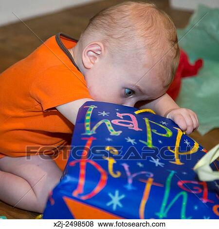 Wheat Ridge, Colorado - Little boy looks for presents on his first birthday. View Large Photo Image Stock Photo - Wheat Ridge, Colorado - Little boy looks for presents on his first birthday.. Fotosearch
