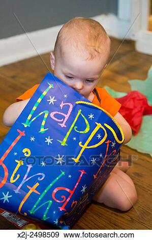Wheat Ridge, Colorado - Little boy looks for presents on his first birthday. View Large Photo Image Stock Photo - Wheat Ridge, Colorado - Little boy looks for presents on his first birthday.. Fotosearch