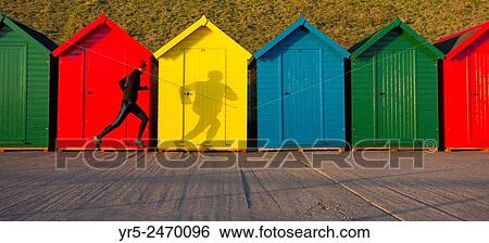 Whitby, North Yorkshire, England, United Kingdom. Europe. Mature jogger passing beach huts on Whitby beach just after sunrise. View Large Photo Image Stock Photograph - Whitby, North Yorkshire, England, United Kingdom. Europe. Mature jogger passing beach huts on Whitby beach just after sunrise.. Fotosearch