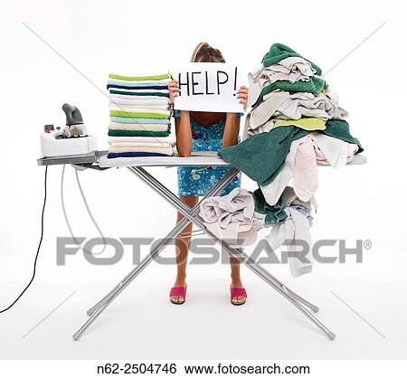 Stock Photograph - Woman behind a board covered with clothes to be ironed, exposes a sign reading aid.. Fotosearch