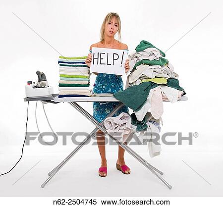 Woman behind a board covered with clothes to be ironed, exposes a sign reading aid. View Large Photo Image Stock Photography - Woman behind a board covered with clothes to be ironed, exposes a sign reading aid.. Fotosearch