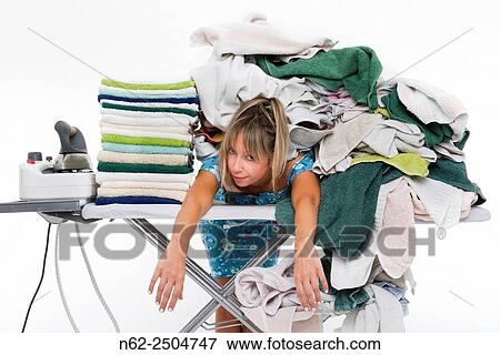 Stock Photo - Woman bent over a board covered with a lot of clothes.. Fotosearch