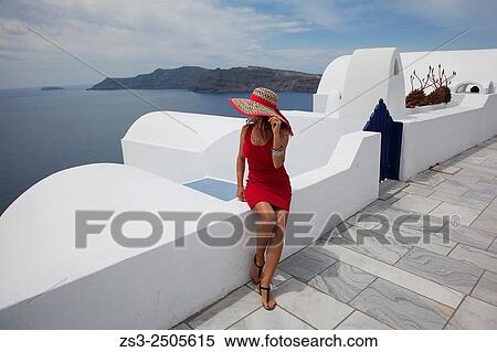Woman sitting at the cliff looking down to Caldera, Oia town, Santorini, Cyclades Islands, Greek Islands, Greece, Europe. View Large Photo Image Stock Photography - Woman sitting at the cliff looking down to Caldera, Oia town, Santorini, Cyclades Islands, Greek Islands, Greece, Europe.. Fotosearch